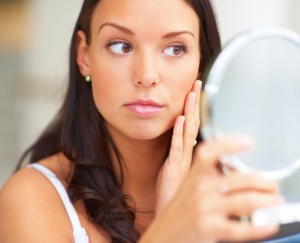 Woman-looking-at-her-face-in-mirror